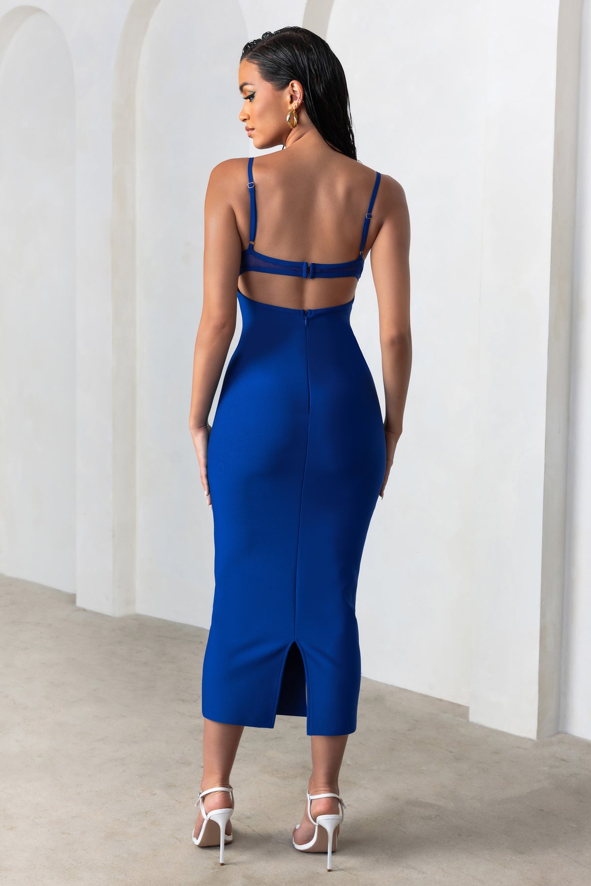 Woman in a black spaghetti-strap dress seen from behind
